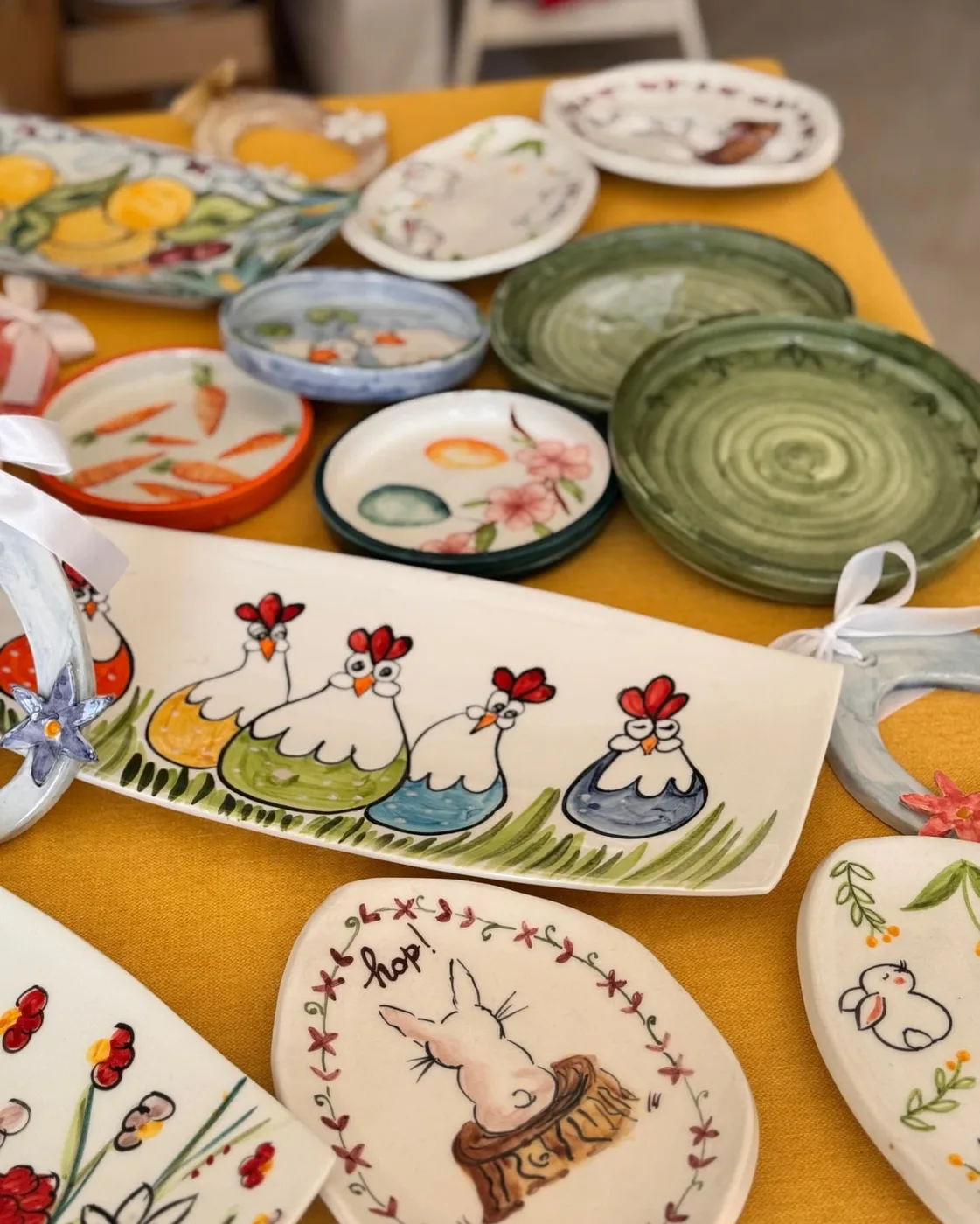 Piatti e vassoi con le galline, su una tovaglia gialla