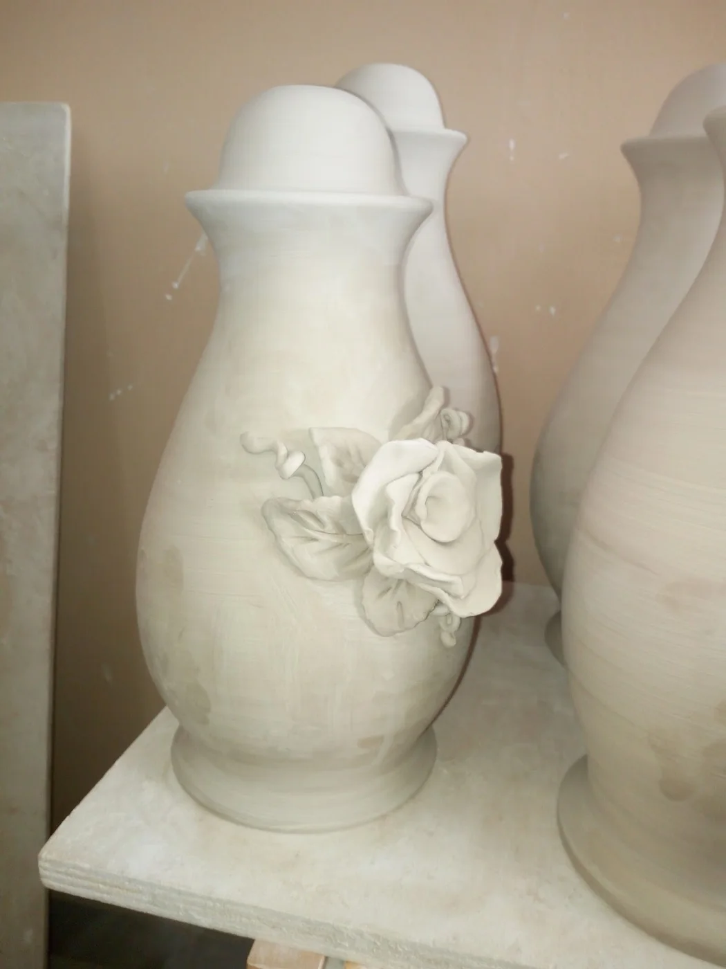 Vasi in ceramica bianca con rose modellate a mano